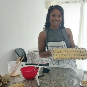Guest showing a tray of handmade pasta after class